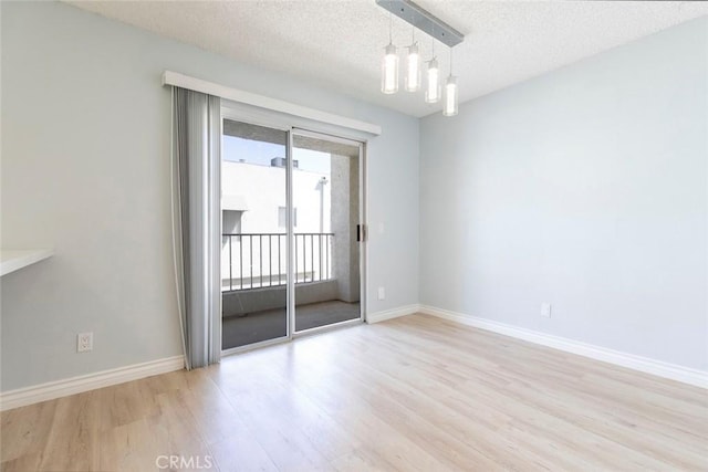 12411 Osborne St Unit 114, Pacoima, CA 91331 - empty room featuring wood finished floors, a textured ceiling, and a chandelier