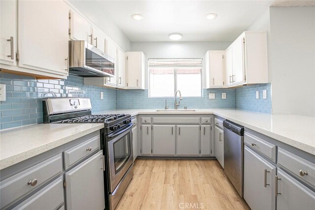 12411 Osborne St Unit 114, Pacoima, CA 91331 - kitchen with stainless steel appliances, gray cabinetry, light wood-type flooring, decorative backsplash, and recessed lighting