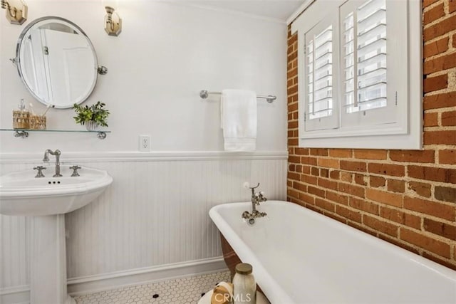 1780 Ocean Blvd, Pismo Beach, CA 93449 - bathroom with a freestanding bath, wainscoting, brick wall, and tile patterned flooring