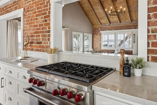 1780 Ocean Blvd, Pismo Beach, CA 93449 - kitchen with high end stainless steel range oven, wood ceiling, brick wall, a chandelier, and white cabinets