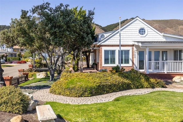 1780 Ocean Blvd, Pismo Beach, CA 93449 - view of front of home featuring brick siding, a front lawn, and a mountain view