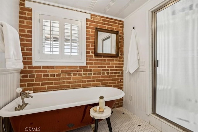 1780 Ocean Blvd, Pismo Beach, CA 93449 - bathroom featuring a freestanding bath, tile patterned floors, crown molding, brick wall, and a decorative wall
