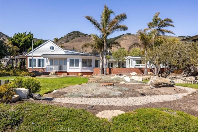 1780 Ocean Blvd, Pismo Beach, CA 93449 - view of front facade featuring a mountain view, brick siding, and a front yard