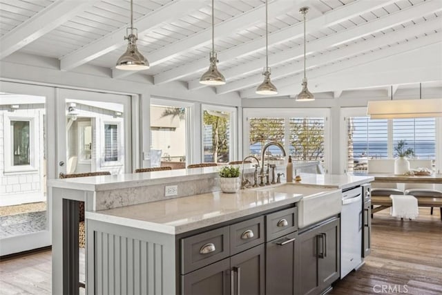 1780 Ocean Blvd, Pismo Beach, CA 93449 - kitchen featuring dishwasher, dark wood finished floors, light stone countertops, pendant lighting, and a center island with sink