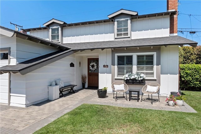 414 Faye Ln, Redondo Beach, CA 90277 - view of front of house featuring a shingled roof, a front lawn, a chimney, board and batten siding, and a patio area