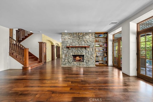 79 Dapplegray Ln, Rolling Hills Estates, CA 90274 - unfurnished living room featuring wood finished floors, arched walkways, a stone fireplace, stairs, and recessed lighting