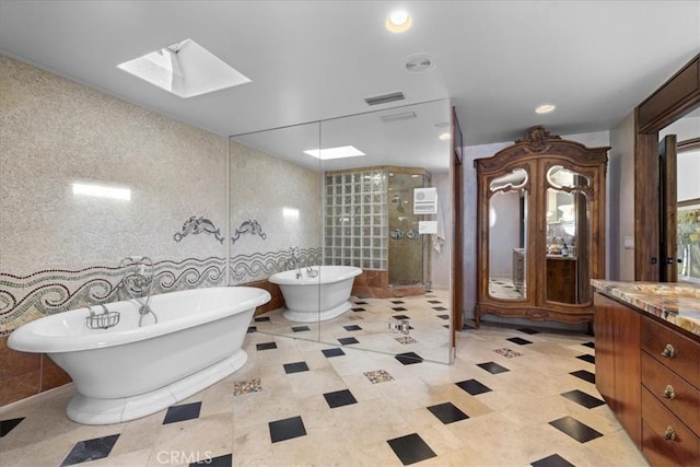 79 Dapplegray Ln, Rolling Hills Estates, CA 90274 - bathroom featuring vanity, a shower stall, a soaking tub, a skylight, and tile walls