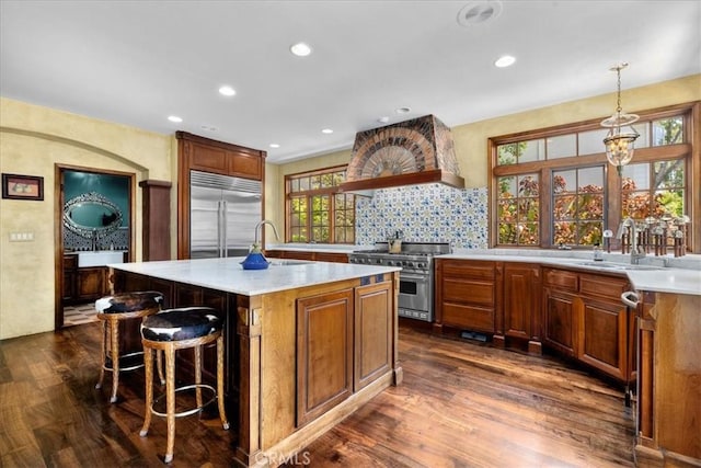79 Dapplegray Ln, Rolling Hills Estates, CA 90274 - kitchen with high quality appliances, dark wood-type flooring, light countertops, a breakfast bar area, and a center island with sink