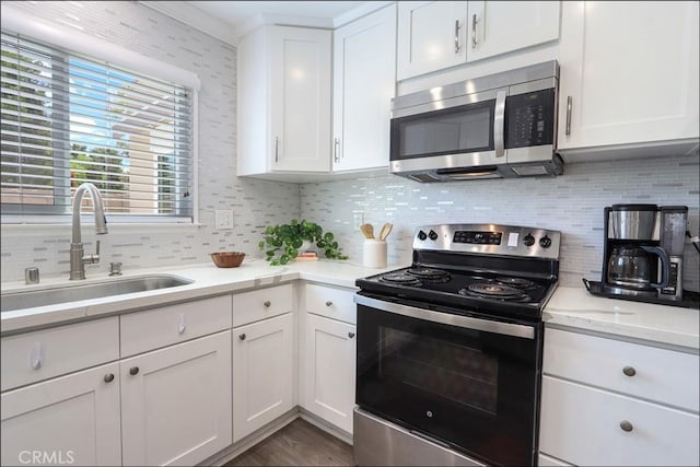 2358 Via Mariposa E Unit B, Laguna Woods, CA 92637 - kitchen with stainless steel appliances, backsplash, white cabinets, and dark wood finished floors