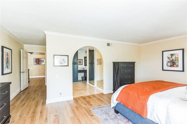27201 Via Aurora, Mission Viejo, CA 92691 - bedroom featuring arched walkways, light wood-style floors, and ornamental molding