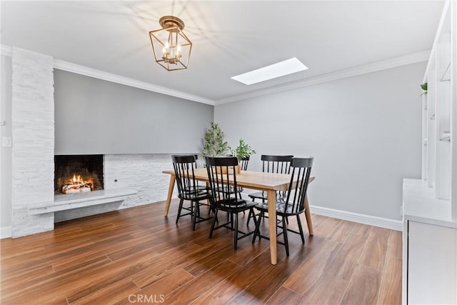 1915 Mariners Dr, Newport Beach, CA 92660 - dining room with a skylight, wood finished floors, ornamental molding, a stone fireplace, and a chandelier