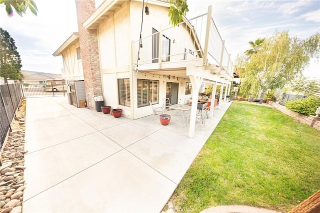 13685 Hidden Valley Rd, Victorville, CA 92395 - back of house featuring a balcony, a patio area, a chimney, and stucco siding