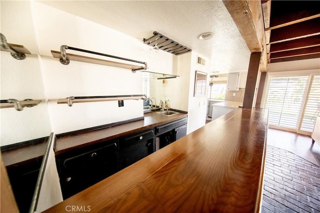 13685 Hidden Valley Rd, Victorville, CA 92395 - kitchen featuring a textured ceiling, white cabinetry, and butcher block counters