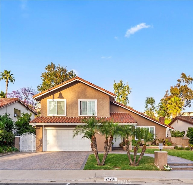 24236 Via, San Clemente, Mission Viejo, CA 92692 - view of front of home featuring a garage, a tiled roof, decorative driveway, a gate, and stucco siding