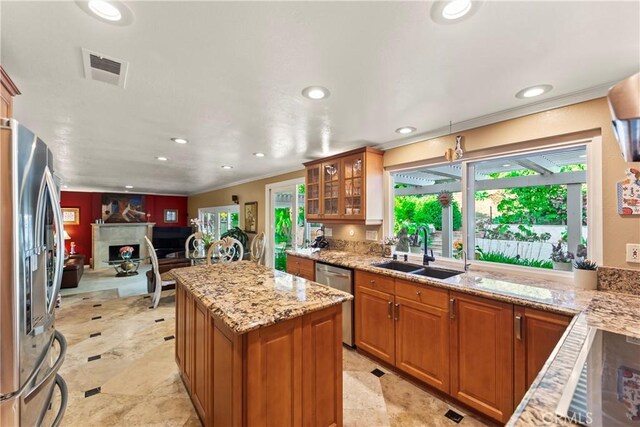 24236 Via, San Clemente, Mission Viejo, CA 92692 - kitchen featuring stainless steel appliances, plenty of natural light, ornamental molding, light stone countertops, and glass insert cabinets