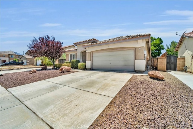 43627 Rialto Dr, Lancaster, CA 93535 - mediterranean / spanish home featuring a gate, an attached garage, stucco siding, driveway, and a tile roof