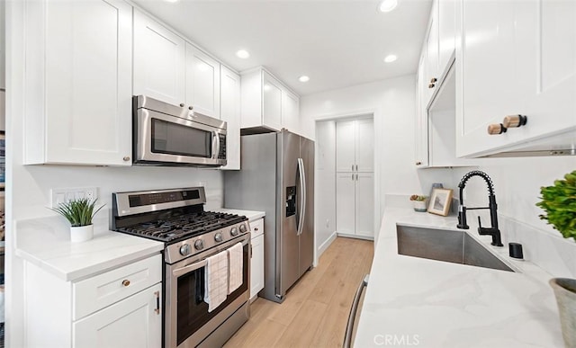 6567 Woodburn Ln Unit 7, Yorba Linda, CA 92886 - kitchen with stainless steel appliances, white cabinetry, light wood-style floors, recessed lighting, and light stone counters