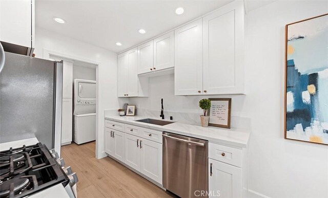 6567 Woodburn Ln Unit 7, Yorba Linda, CA 92886 - kitchen with stainless steel appliances, stacked washer / dryer, white cabinetry, light wood-style flooring, and recessed lighting