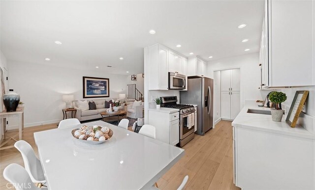 6567 Woodburn Ln Unit 7, Yorba Linda, CA 92886 - kitchen with stainless steel appliances, white cabinetry, light countertops, recessed lighting, and open floor plan