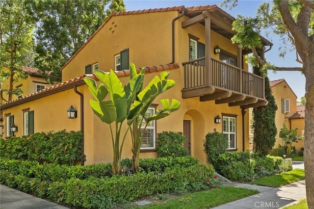 78 Windchime, Irvine, CA 92603 - view of property exterior featuring a balcony, stucco siding, and a tiled roof