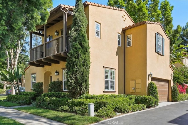 78 Windchime, Irvine, CA 92603 - view of property exterior with an attached garage, stucco siding, a balcony, and a tiled roof