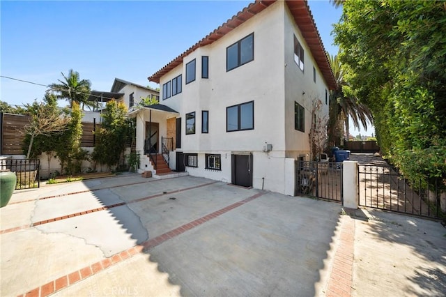 1409 Laveta, Los Angeles, CA 90026 - view of front of house featuring stucco siding, a gate, a patio area, and a tile roof