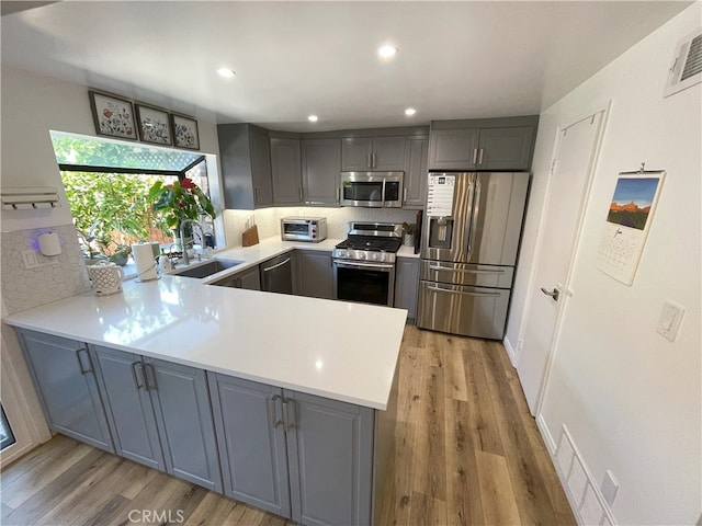 9749 Reseda Blvd Unit 13, Northridge, CA 91324 - kitchen with stainless steel appliances, a peninsula, gray cabinetry, and recessed lighting