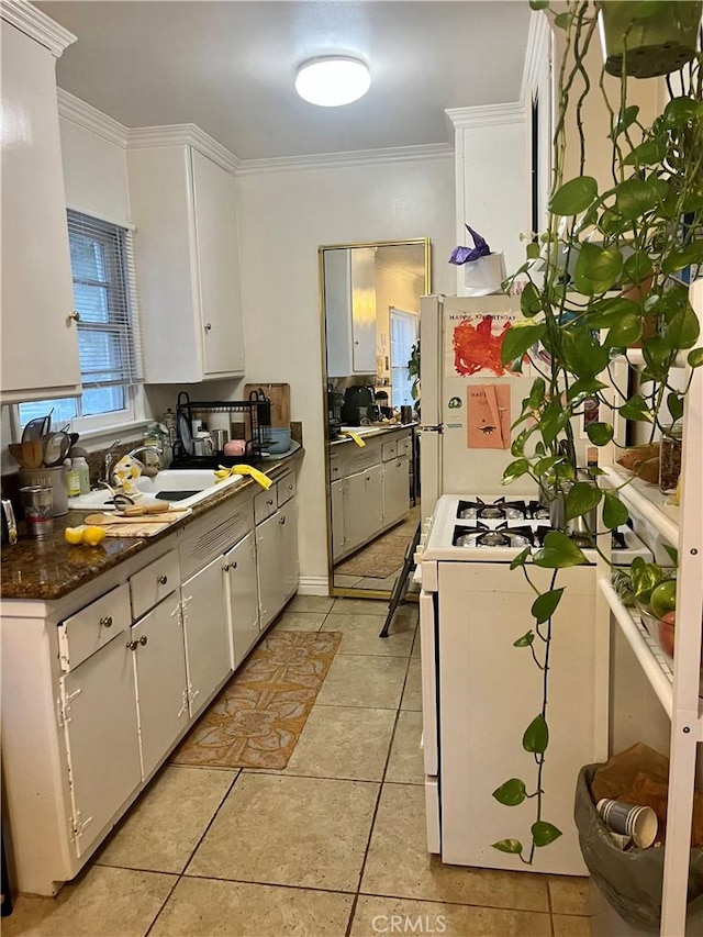 11316 Venice Blvd, Los Angeles, CA 90066 - kitchen with white appliances, white cabinets, crown molding, light tile patterned floors, and dark countertops
