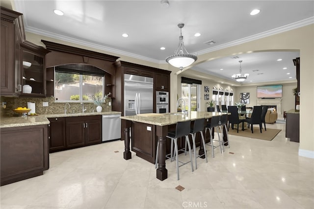 15841 Aurora Crest Dr, Whittier, CA 90605 - kitchen featuring appliances with stainless steel finishes, a breakfast bar area, arched walkways, backsplash, and ornamental molding