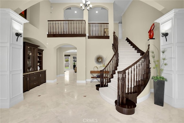 15841 Aurora Crest Dr, Whittier, CA 90605 - foyer with arched walkways, a chandelier, stairs, crown molding, and a towering ceiling