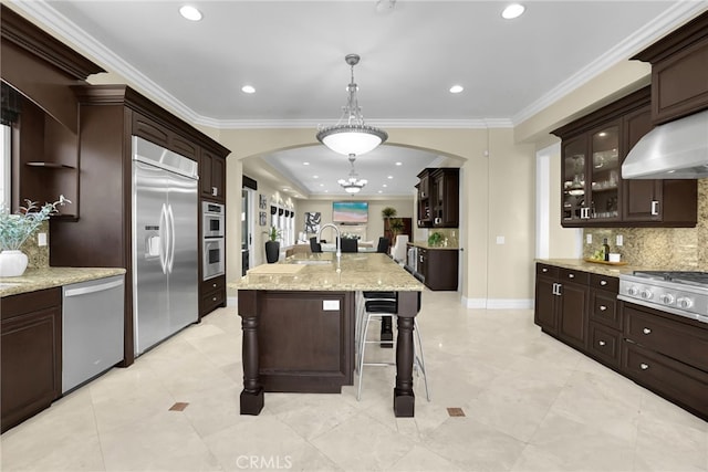 15841 Aurora Crest Dr, Whittier, CA 90605 - kitchen featuring appliances with stainless steel finishes, arched walkways, tasteful backsplash, crown molding, and a breakfast bar