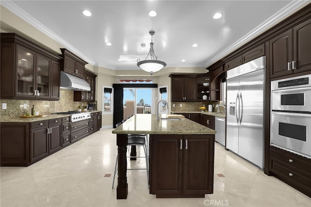 15841 Aurora Crest Dr, Whittier, CA 90605 - kitchen with appliances with stainless steel finishes, under cabinet range hood, backsplash, dark brown cabinets, and glass insert cabinets
