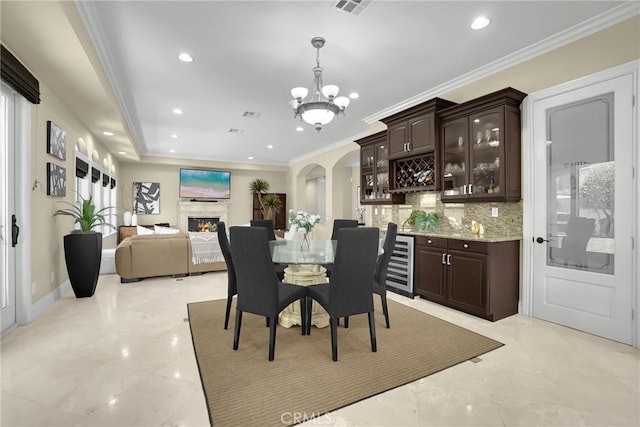 15841 Aurora Crest Dr, Whittier, CA 90605 - dining room with a chandelier, arched walkways, wine cooler, recessed lighting, and a lit fireplace