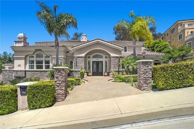 15841 Aurora Crest Dr, Whittier, CA 90605 - mediterranean / spanish-style house featuring french doors, stone siding, stucco siding, a tile roof, and a chimney