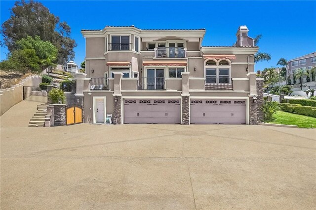 15841 Aurora Crest Dr, Whittier, CA 90605 - mediterranean / spanish-style house featuring a balcony, a garage, stucco siding, a chimney, and concrete driveway