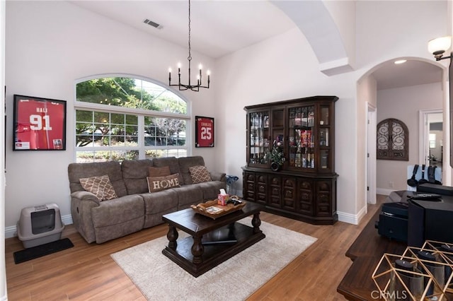 395 Mesa Rd, Nipomo, CA 93444 - living room featuring arched walkways, high vaulted ceiling, wood finished floors, and a chandelier