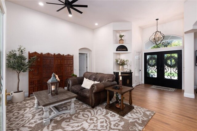 395 Mesa Rd, Nipomo, CA 93444 - living area featuring arched walkways, a high ceiling, wood finished floors, a chandelier, and french doors