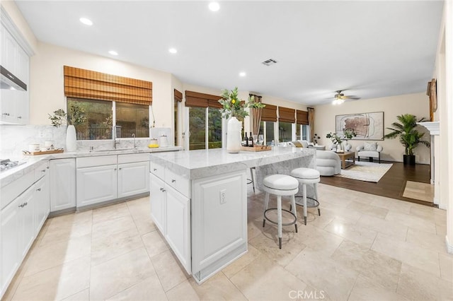 23665 Ridgecrest Ct, Diamond Bar, CA 91765 - kitchen featuring a ceiling fan, a center island, a breakfast bar area, recessed lighting, and white cabinetry