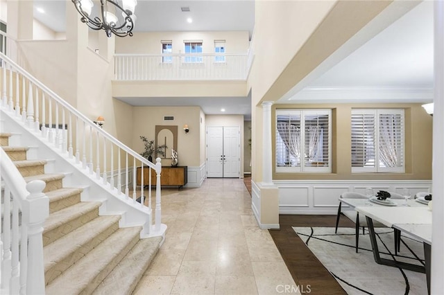23665 Ridgecrest Ct, Diamond Bar, CA 91765 - foyer featuring stairs, ornate columns, a high ceiling, wainscoting, and a decorative wall