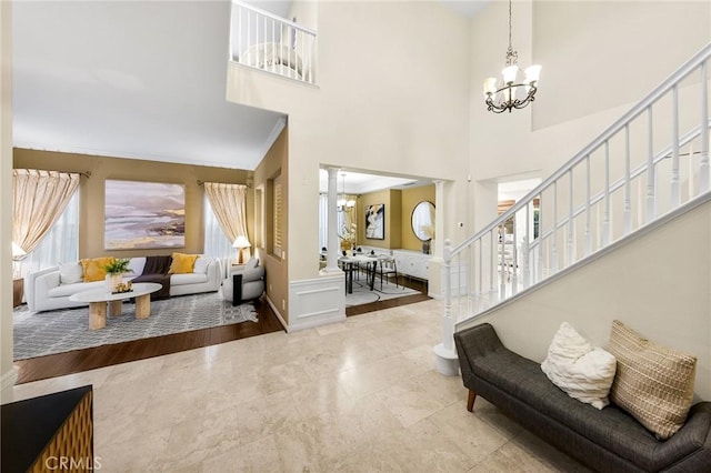 23665 Ridgecrest Ct, Diamond Bar, CA 91765 - entrance foyer with a chandelier, stairway, a high ceiling, wainscoting, and decorative columns