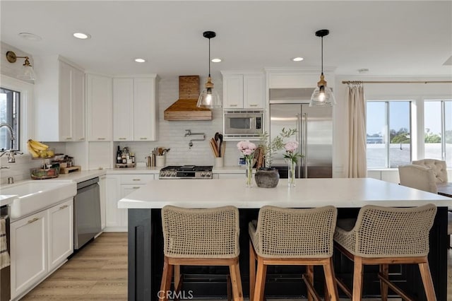 1722 Harper Ave, Redondo Beach, CA 90278 - kitchen with built in appliances, custom range hood, backsplash, white cabinetry, and a kitchen island