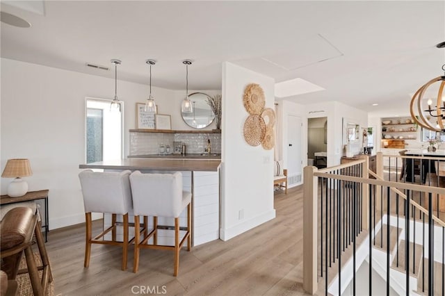 1722 Harper Ave, Redondo Beach, CA 90278 - kitchen with light wood-style floors, decorative backsplash, pendant lighting, and a kitchen breakfast bar