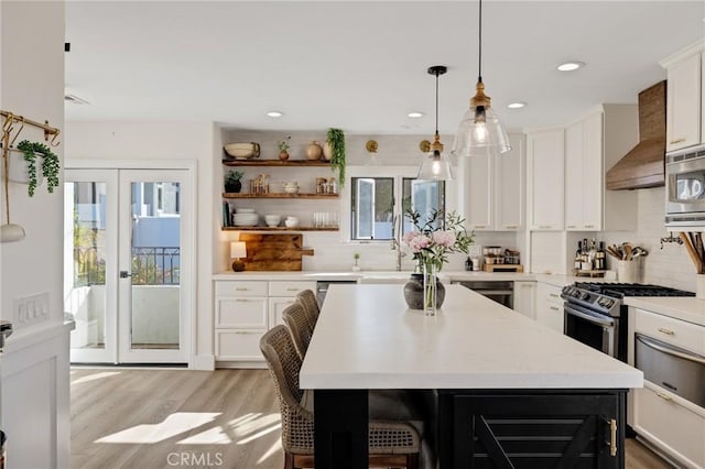1722 Harper Ave, Redondo Beach, CA 90278 - kitchen with wall chimney range hood, light wood finished floors, tasteful backsplash, white cabinets, and recessed lighting