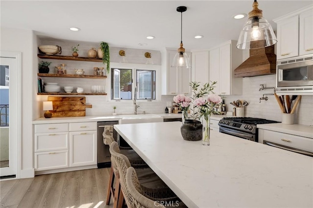 1722 Harper Ave, Redondo Beach, CA 90278 - kitchen featuring stainless steel appliances, white cabinets, custom range hood, light wood-style flooring, and tasteful backsplash