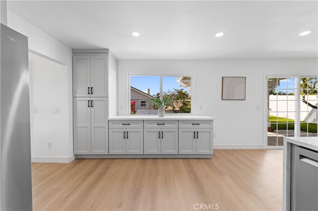 25885 Astor Way, Lake Forest, CA 92630 - kitchen with light wood-style floors, light countertops, recessed lighting, gray cabinets, and freestanding refrigerator