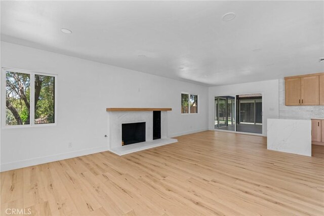 151 Barret Rd, Riverside, CA 92507 - unfurnished living room with healthy amount of natural light, a fireplace with raised hearth, and light wood-style floors