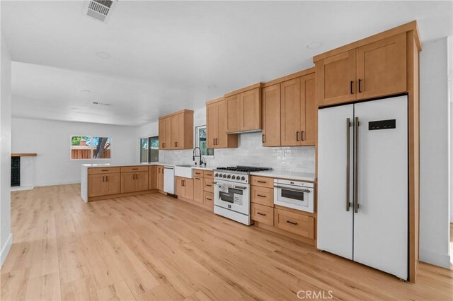 151 Barret Rd, Riverside, CA 92507 - kitchen featuring high quality appliances, light wood-type flooring, backsplash, light countertops, and a peninsula