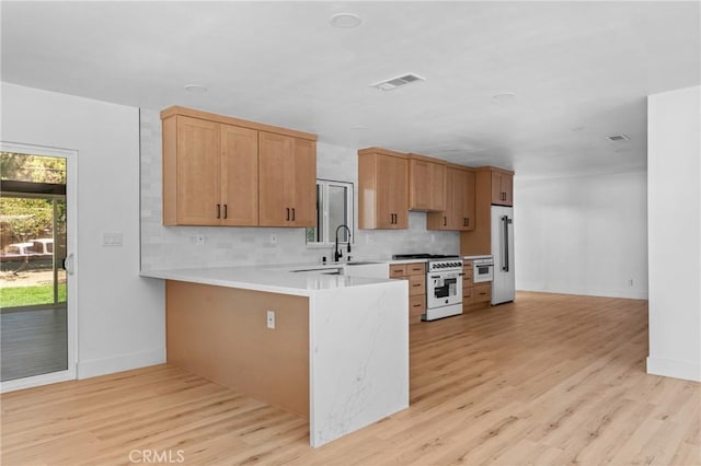 151 Barret Rd, Riverside, CA 92507 - kitchen featuring high quality appliances, light countertops, tasteful backsplash, light wood-style floors, and a peninsula