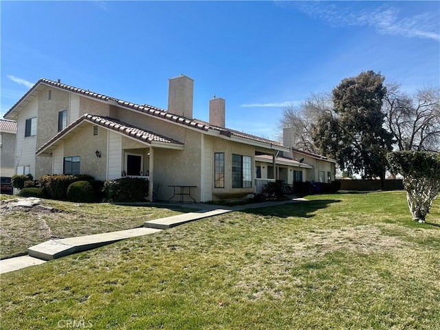 43731 8th St E, Lancaster, CA 93535 - view of property exterior with a chimney, stucco siding, and a lawn