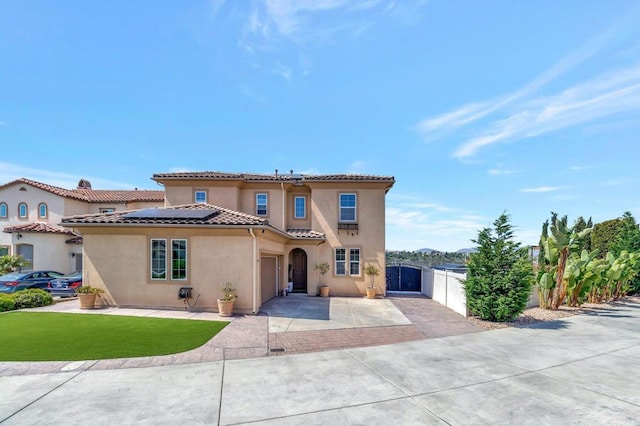 1349 Pyramid Peak St, Chula Vista, CA 91913 - mediterranean / spanish-style house featuring driveway, roof mounted solar panels, a gate, stucco siding, and a tile roof